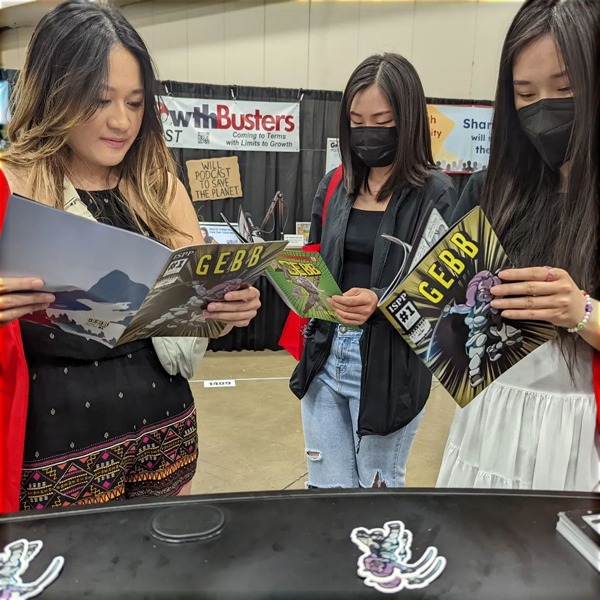 Asian women at EarthX reading GEBB.